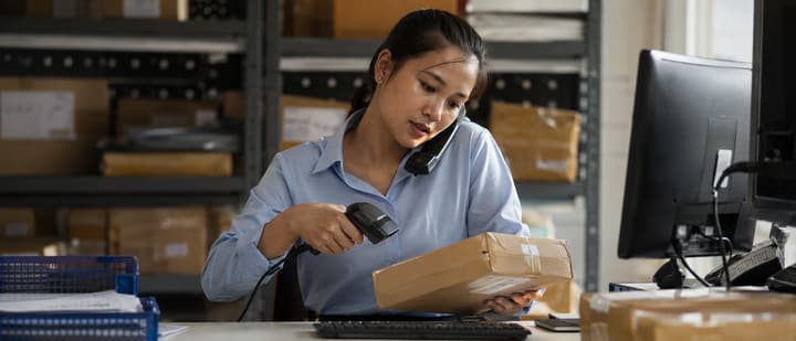 Nhân viên tra soát quét mã kiện hàng thất lạc tại bàn làm việc