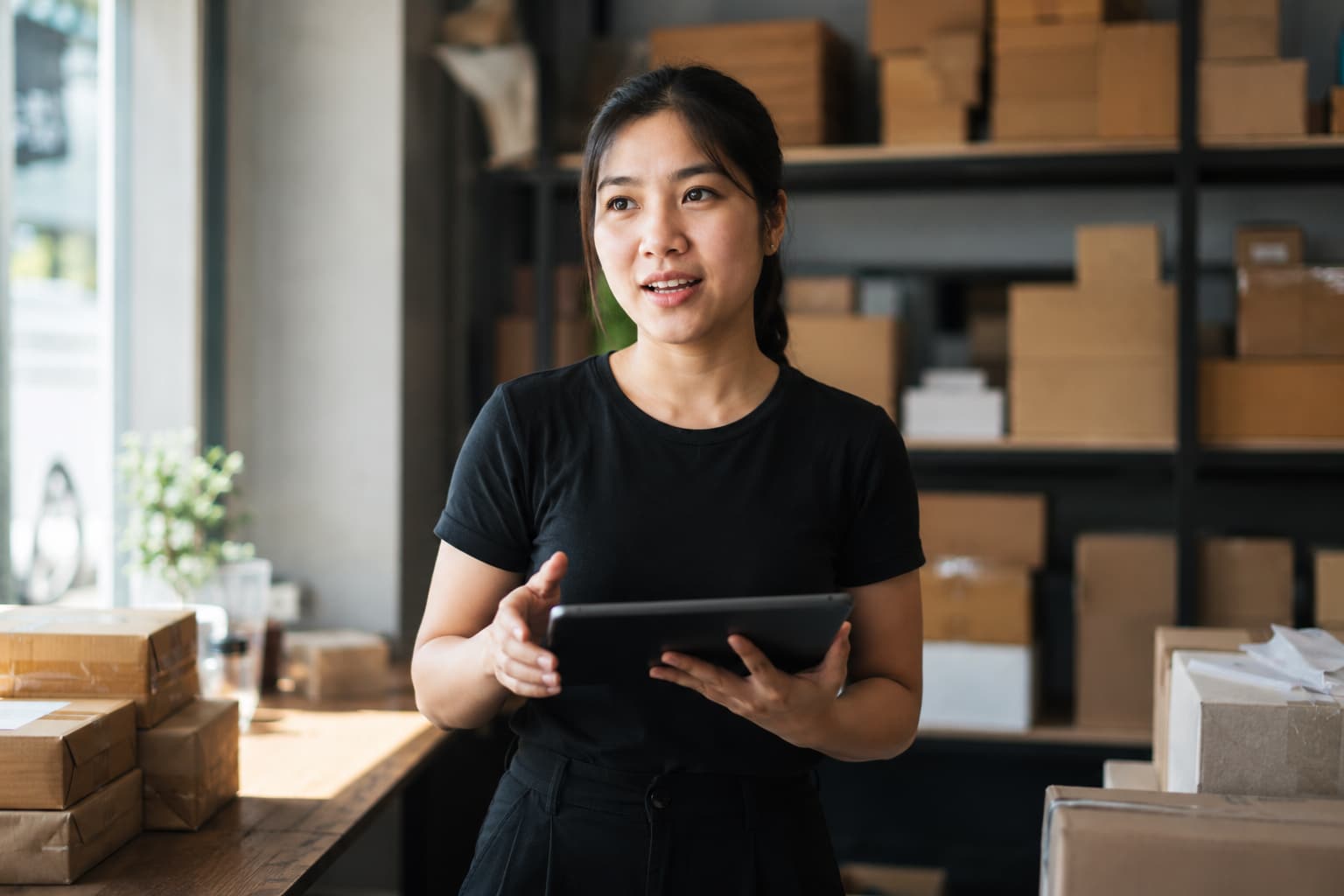 Nhân viên sales chuyển phát tư vấn cho chủ shop giữa kho hàng